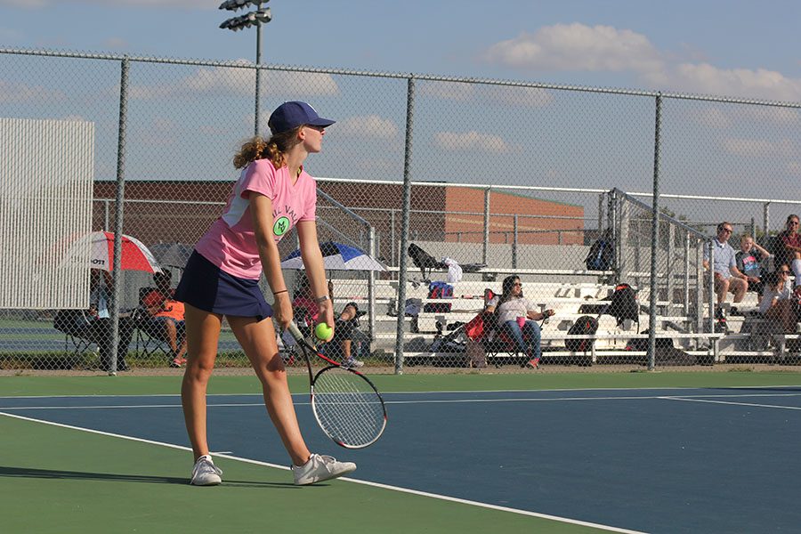 Winding up for a serve, senior Kaley Muir focuses on her opponents during her doubles match on Monday, Oct. 3. At its last regular meet of the season, varsity girls tennis went 6-2.