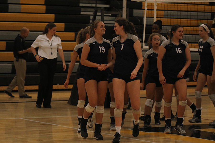After a well played two-set match, sophomore Adelle Warford and senior Maggie Bogart shake hands and smile at each other on a job well done, regardless of falling to the Blue Valley Tigers.