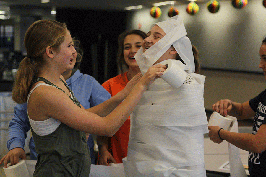 Freshman Sydney Ebner wraps her friend in toilet paper during a stress free seminar on Wednesday, Oct. 19. "This has been really fun with my friends, we've been coloring and just hanging out," Ebner said.
