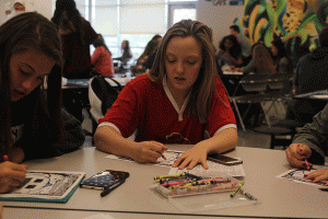 Coloring a picture during the stress free seminar, freshman Maddie Allen spends time with her friends. "Doing activities like this helps you [to] relax yourself, and it never hurts to be with friends," Allen said.