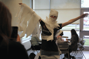 Breaking free from a toilet paper wrapping, senior Diana Auckly poses for a picture. "It felt really satisfying, because it all just ripped," Auckly said.