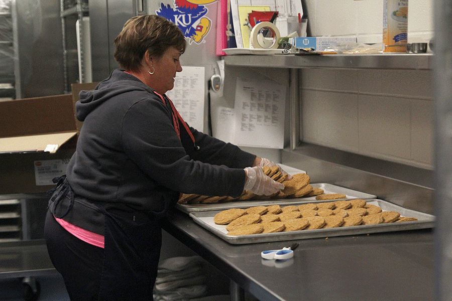 After preheating the oven, student nutrition assistant Michelle Kile spreads chicken patties onto a pan on Friday, Oct. 28.