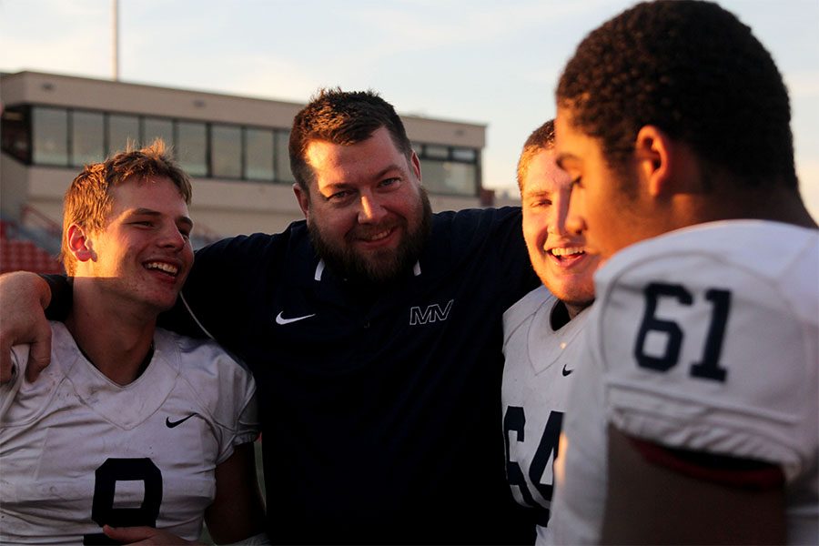 Coach Alex Houlton laughs with junior Brody Flaming and senior Jacob Campbell.