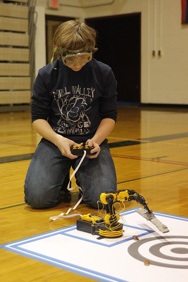 While controlling a robot arm, sophomore Andrew Thomas concentrates to finish his task at the Olathe North Science Olympiad meet on Saturday, Nov. 19.