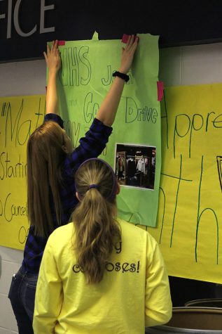 Senior Rachel Rule hangs poster in the foyer Monday, Nov. 7