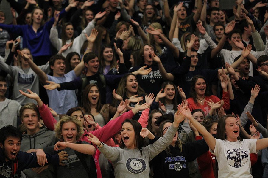 Junior Kayla Johnson cheers with her classmates as television cameras pan the bleachers.