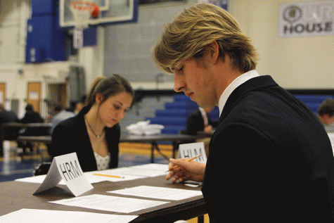 Before competing, senior Garrison Fangman writes down key ideas to discuss.