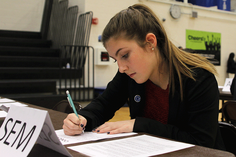 While preparing for her competition, junior Aly Tennis reads over her prompt and writes talking points to cover with her interviewer.