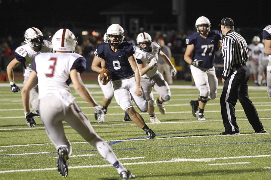 Keeping the ball, junior quarter back Brody Flaming runs down the field.