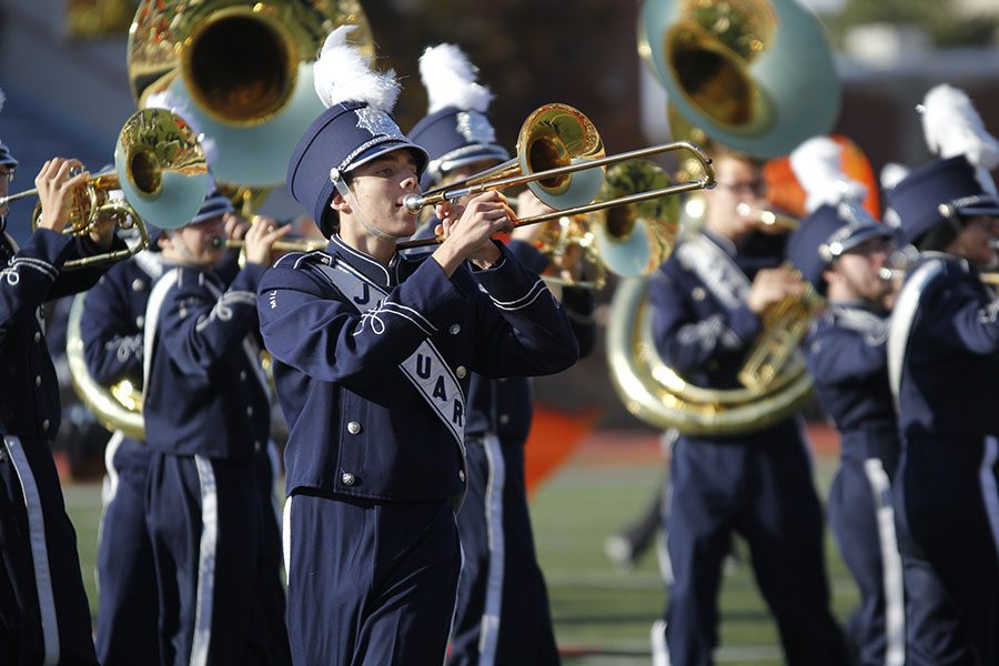 Marching with the band, sophomore Joe McClain plays the trombone.