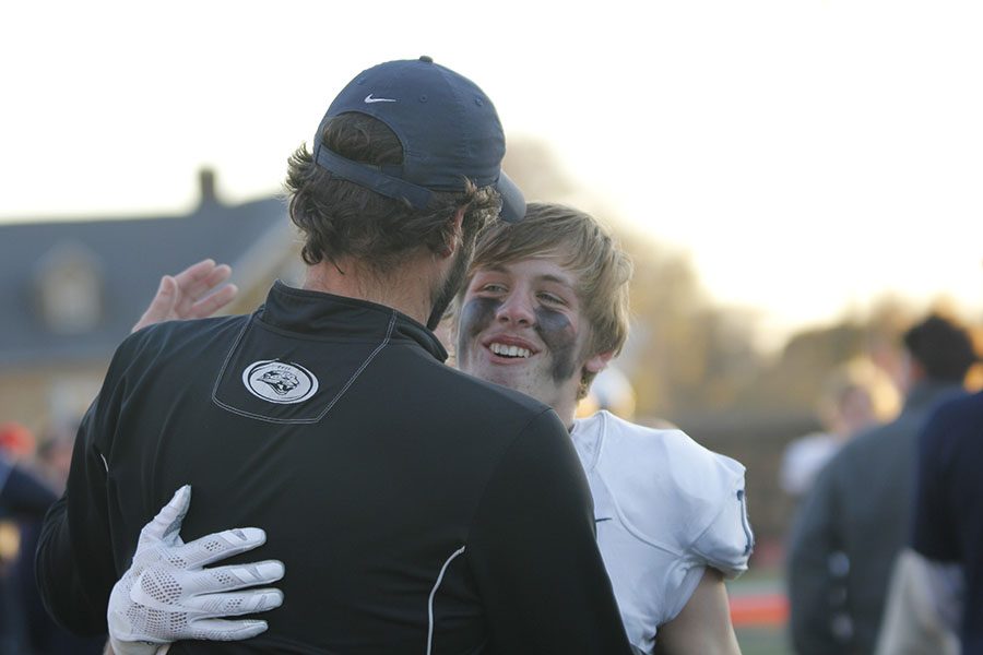 Junior Evan Rice celebrate the state title with offensive coordinator Mike Strack.