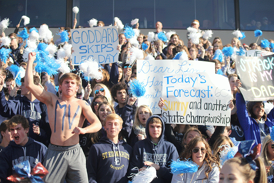 With+junior+Conner+Ward+in+front+leading+the+student+section%2C+other+students+hold+up+signs+to+encourage+the+players.%0A