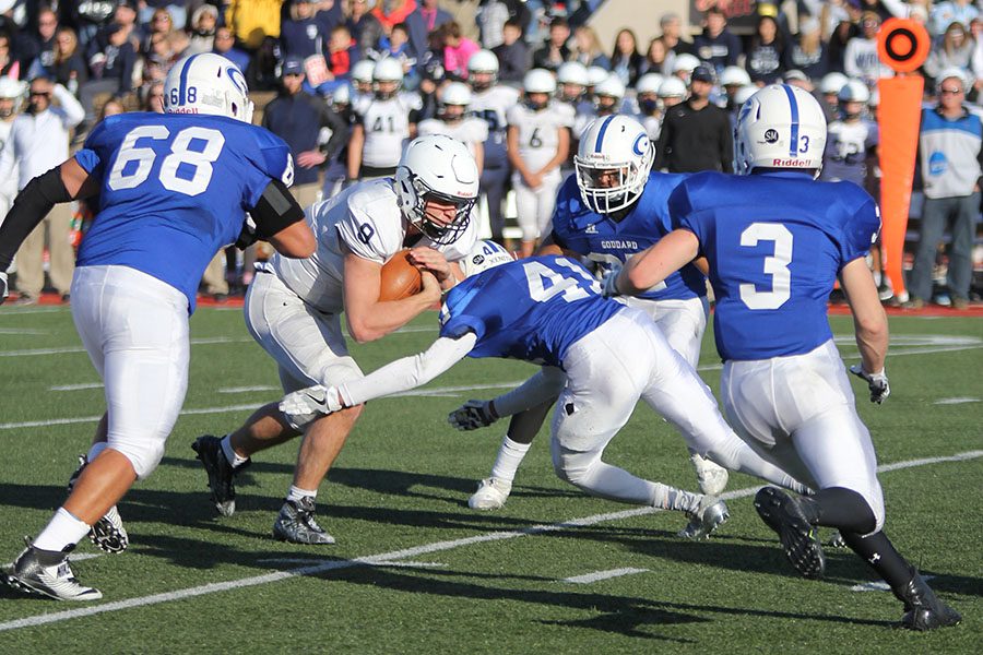  Pushing through the Goddard defense, senior Ben Hartman carries the ball. 
