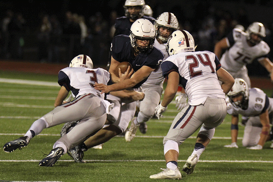 Pushing a St. James defender off of him, junior Brody Flaming continues to advance the ball on Friday, Nov. 11.