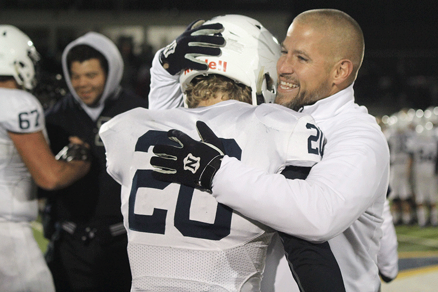 Following the game on Friday, Nov. 18, head coach Joel Applebee hugs senior Jack Eber as they congratulate each other on the win. The Jaguars defeated the Saint Thomas Aquinas Saints and advance to the state championship game to play the Goddard Lions on Saturday, Nov. 26 at Pittsburg State University.