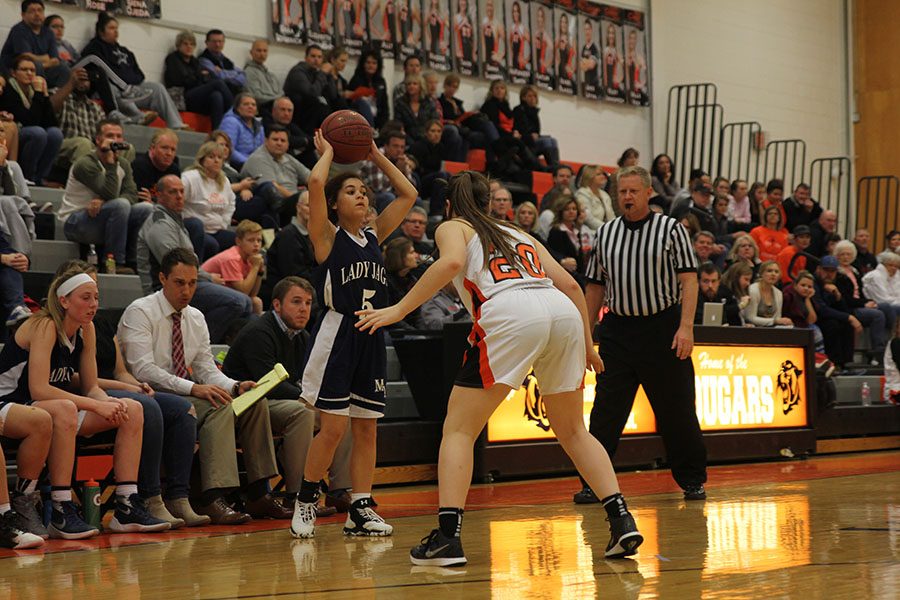 Looking for a teammate open, sophomore Presley Barton holds the ball above her head on Tuesday, Dec. 6. The girls lost against SMNW 36-31.