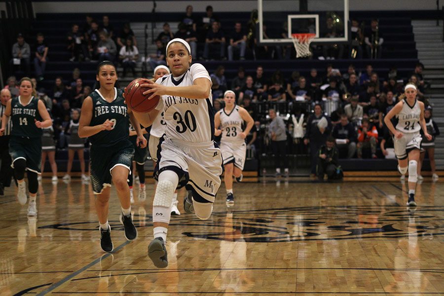 Sprinting ahead of everyone else, senior Elena Artis receives the ball and prepares to dribble.