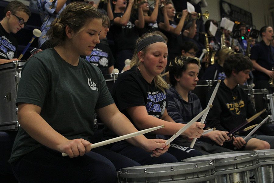 During a time out, freshmen Kaleigh Johnston (left) and Abby Lee (middle) play the snare drum.