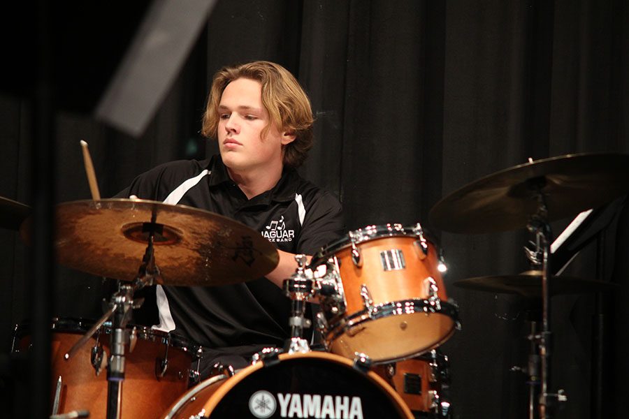 Lifting his drum sticks in the air, senior Spencer Smith prepares to tab the cymbals during the jazz band concert on Thursday, Dec. 1.