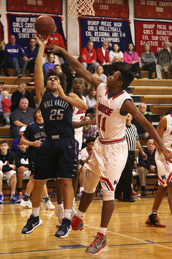 Junior Ike Valencia goes up for a shot against a Bishop Miege player.