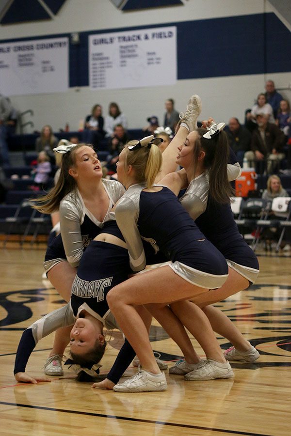 Cheerleaders prepare for a stunt during their halftime performance.