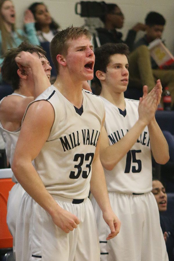 Junior Brody Flaming stands up to cheer on the team.