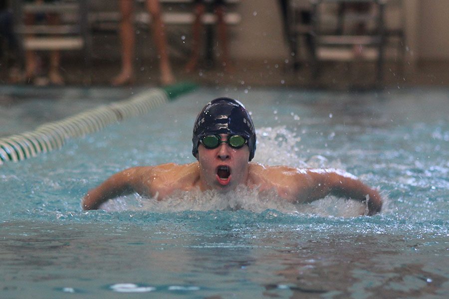 By pushing his arms through the water, freshman Avery Lawson swims butterfly on Tuesday, Jan. 24. 