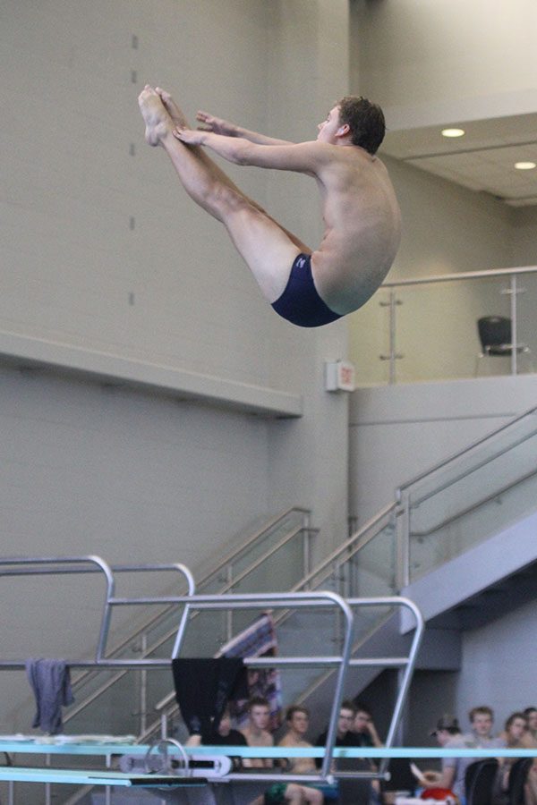 Before entering the water, senior Mitch Willoughby performs a pike as part of his dive.