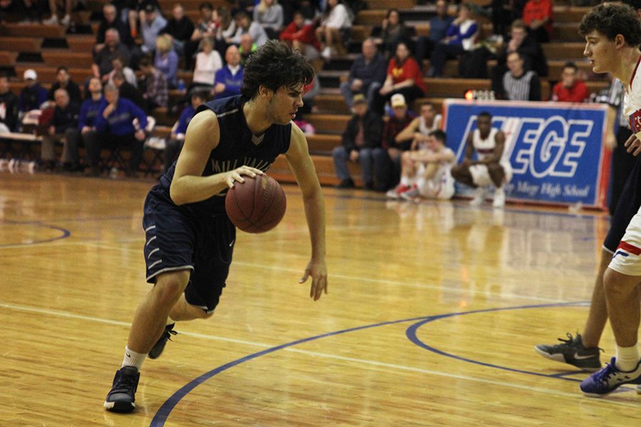 Junior Ike Valencia dribbles down the court at the boys basketball game on Wednesday, Jan. 25.
