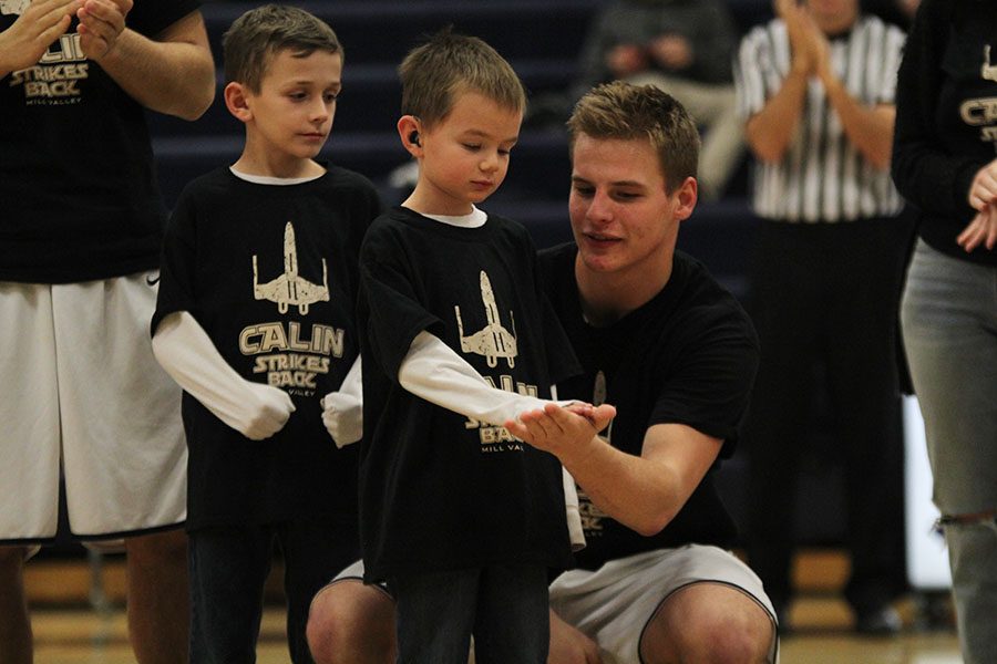 After the Make-A-Wish clubs speech prior to the game on Friday, Jan. 27, junior Brody Flaming high-fives Calin Strahm.