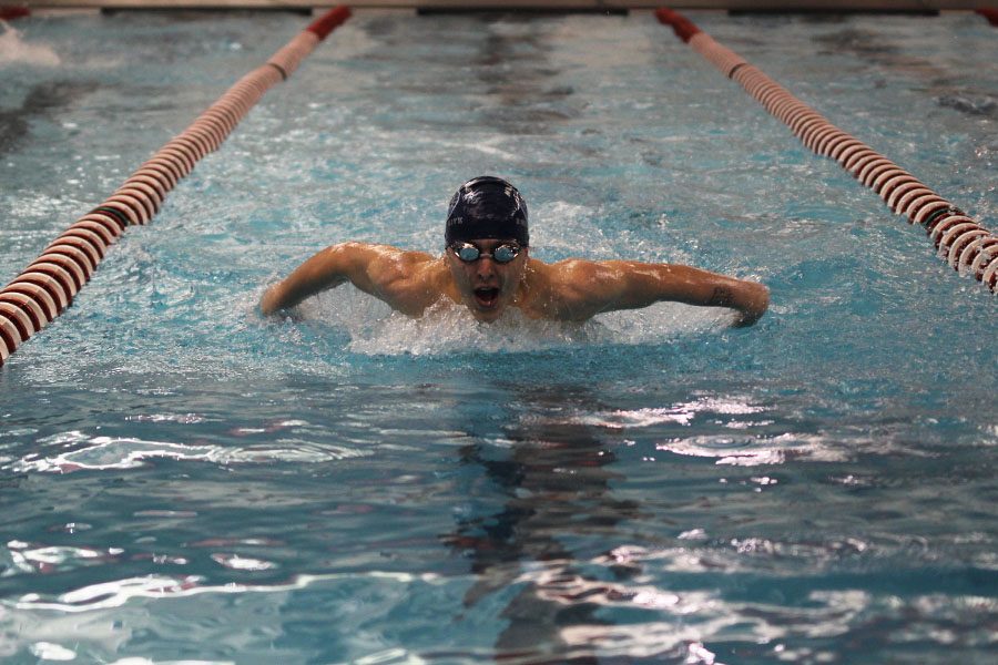 Competing in the 100 yard butterfly, freshman Colby Beggs propels himself forward.