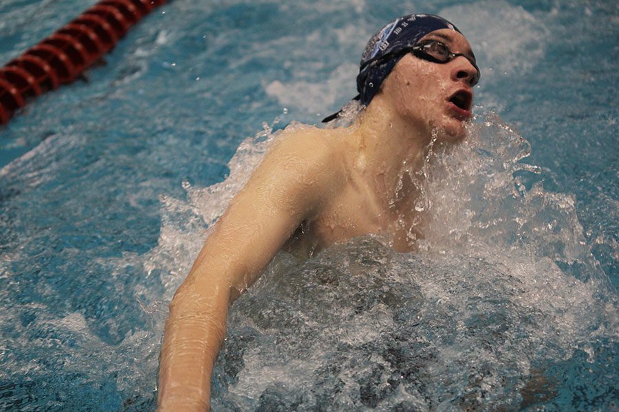 Swimming in the 100 yard breaststroke, sophomore Ethan Forristal gasps for air as he turns back.