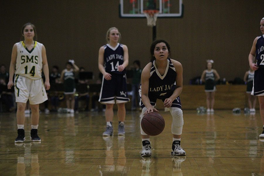 As she looks to shoot a free throw, freshman Presley Barton squats and dribbles the ball on Monday, Jan. 23. The girls team won 75-47 against SMS.