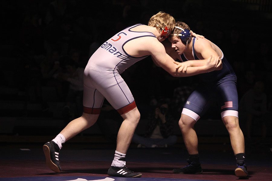 Pushing against his opponent, sophomore Derek Wiedner focuses on his match.
