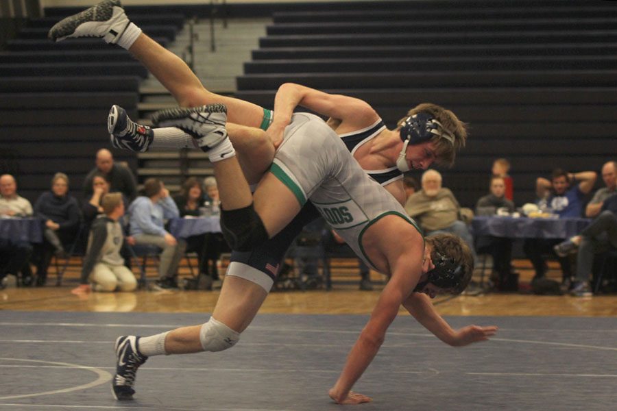 Throwing his opponent to the mat, junior Jarrett Bendure gets a takedown during his match.