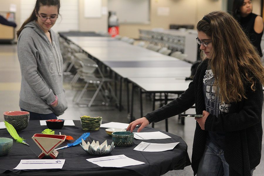 Freshman Joan Downey and Eva Burke look at ceramic bowls on Friday, Jan. 28.