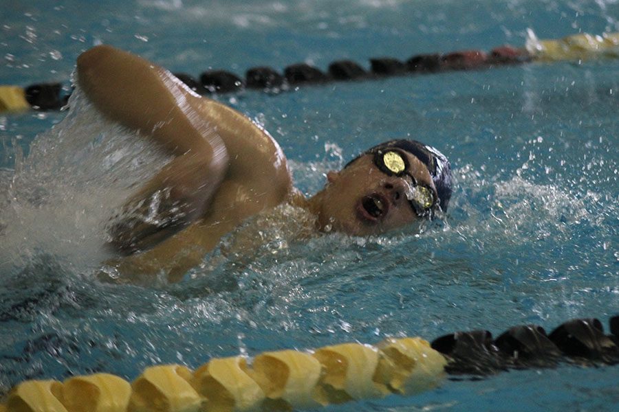 As he goes up for a breath, junior Noah Kemper competes in the 200 yard freestyle race.