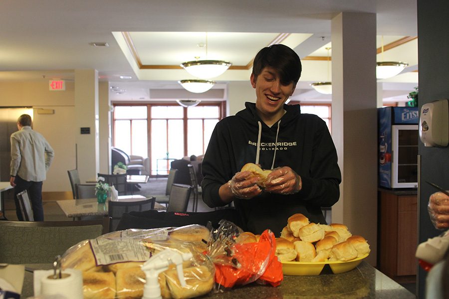 Arranging buns onto a plate, senior Camden Davis smiles.