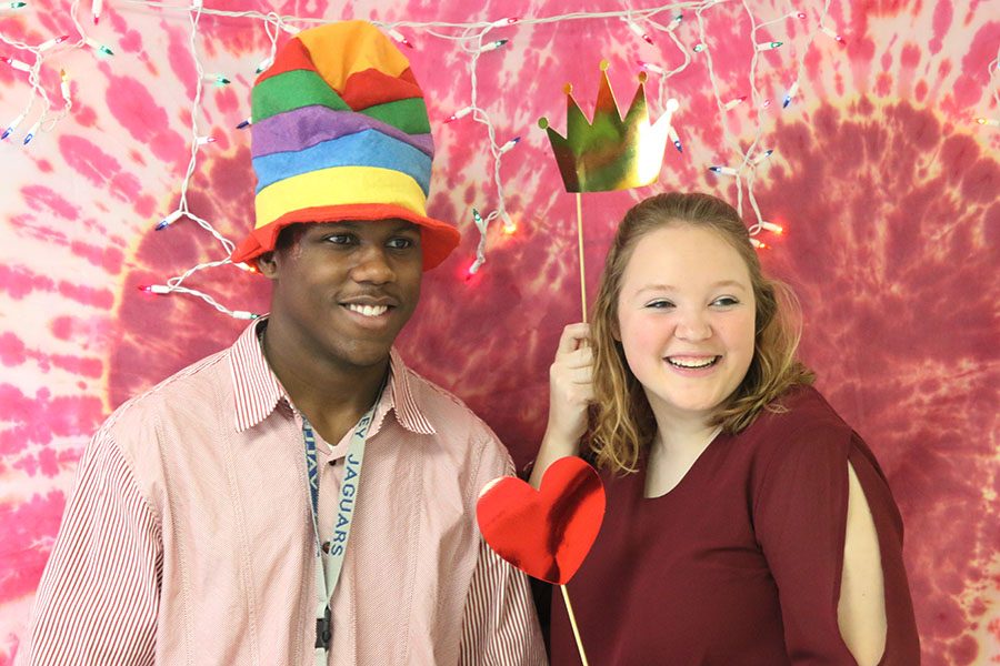 Senior Hanna Hurt poses with junior Malik Redmond using crown and heart props.