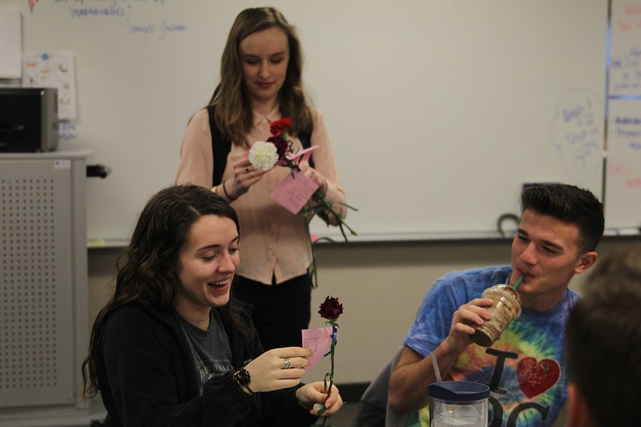 Senior Savannah Chappell smiles as she is given a carnation by NEHS member sophomore Liz Fraka. 