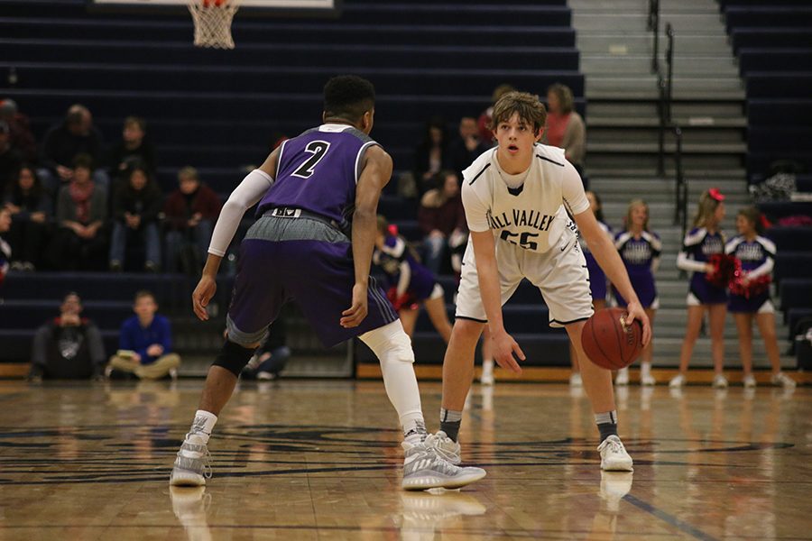 While looking down the court, sophomore Tanner Moore searches for an opening in the Blue Valley Northwest defense during the boys basketball game at home on Tuesday, Feb. 14. Mill Valley ended up losing with a score of 52-82.