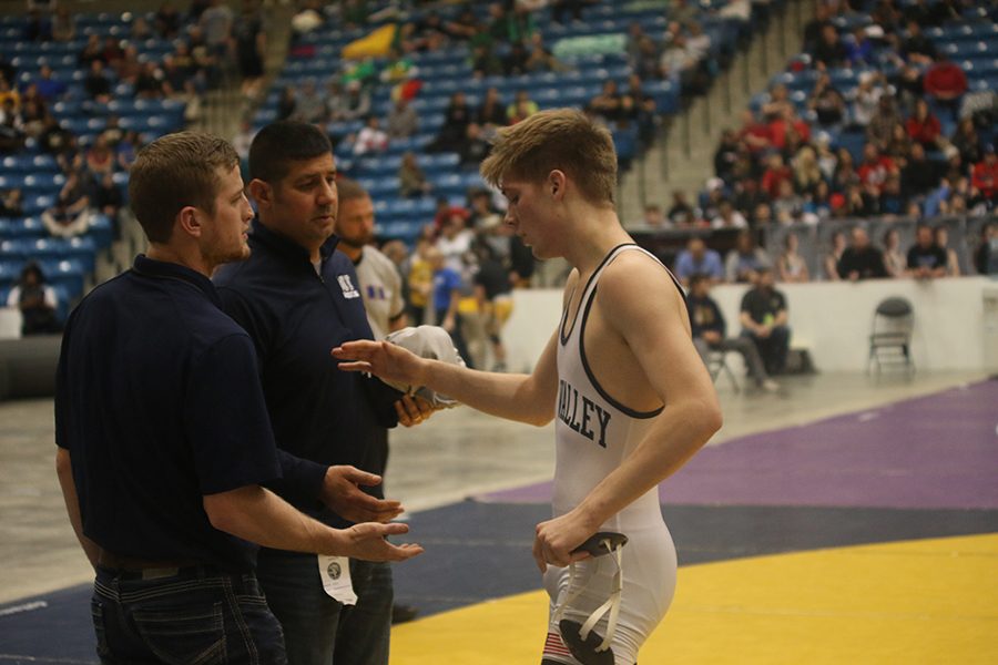 After his match Junior Jarrett Bendure high fives his coaches.