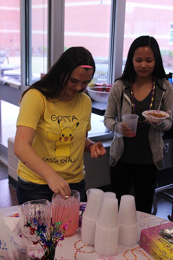 Junior Kate Miller watches as Senior Victoria Nicholson makes punch at Mardi Gras on Friday, Feb. 24.