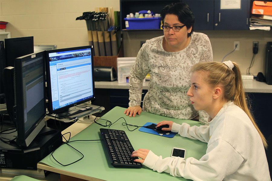 After completing the Rube Goldberg unit, engineering teacher Helga Brown helps junior Natalie Kalma submit a report.