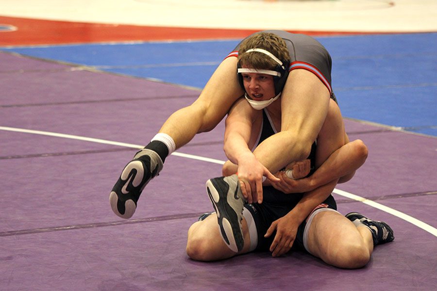 Holding his opponent upside down, senior Jett Bendure catches his breath during consolation rounds at the 5A state wrestling tournament on Saturday, Feb. 25. 