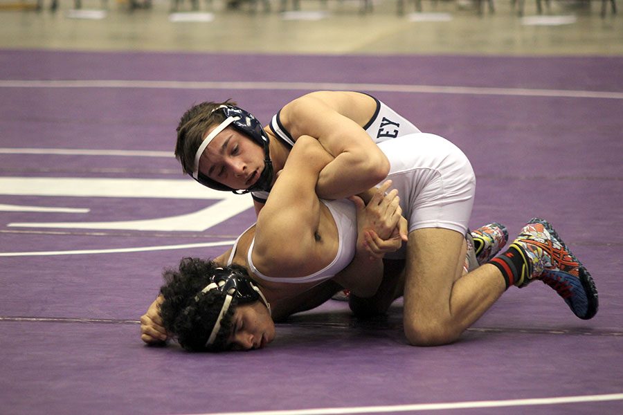 Concentrating during his match, senior Dylan Gowin holds down his opponent. 