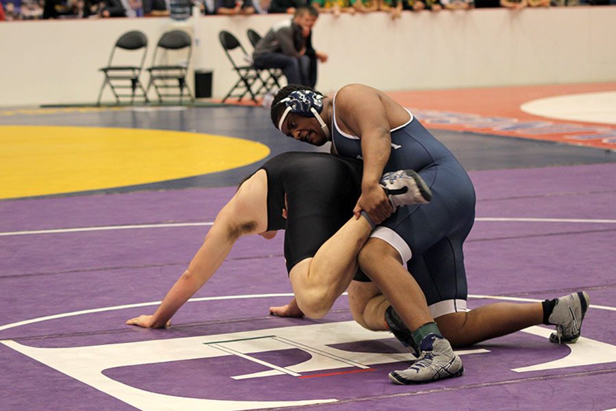 Grabbing his opponent, senior Alec Derritt wrestles during his match.