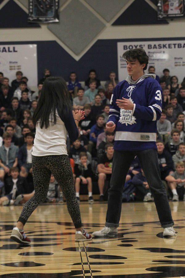 Winter homecoming candidates Mariana Cruz and Sam Brown pause before continuing their handshake.