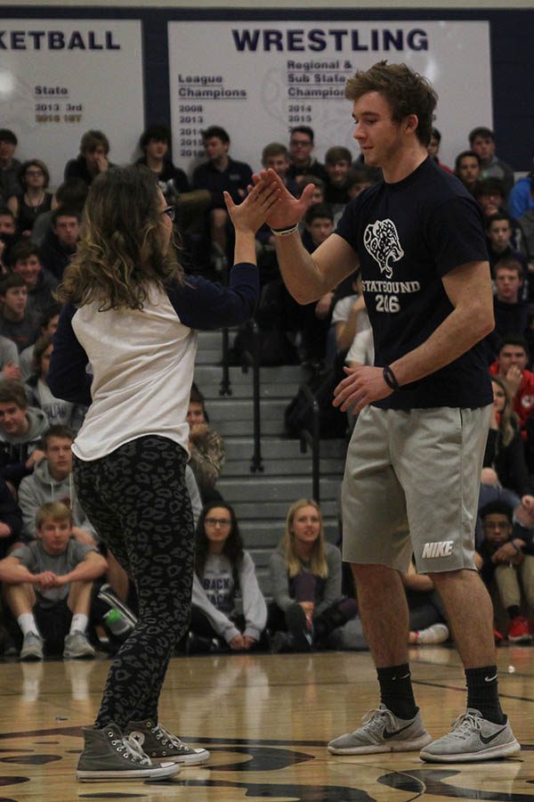 Winter homecoming candidates Melissa Kelley and Joel Donn high five each other as they are introduced.