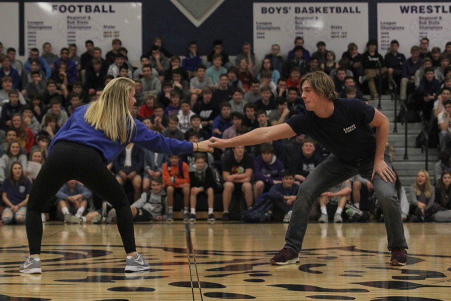 Reaching for each other, winter homecoming candidates Kasey Meeks and Garrison Fangman walk onto the floor.